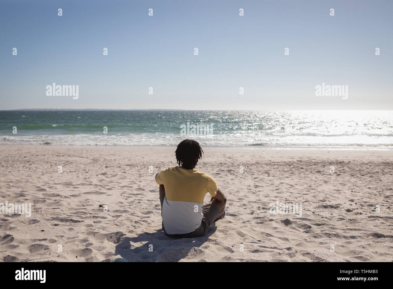 Uomo relax in spiaggia in una giornata di sole Foto Stock