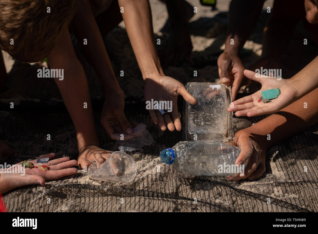 Volontari ricerca di rifiuti con una rete alla spiaggia in una giornata di sole Foto Stock