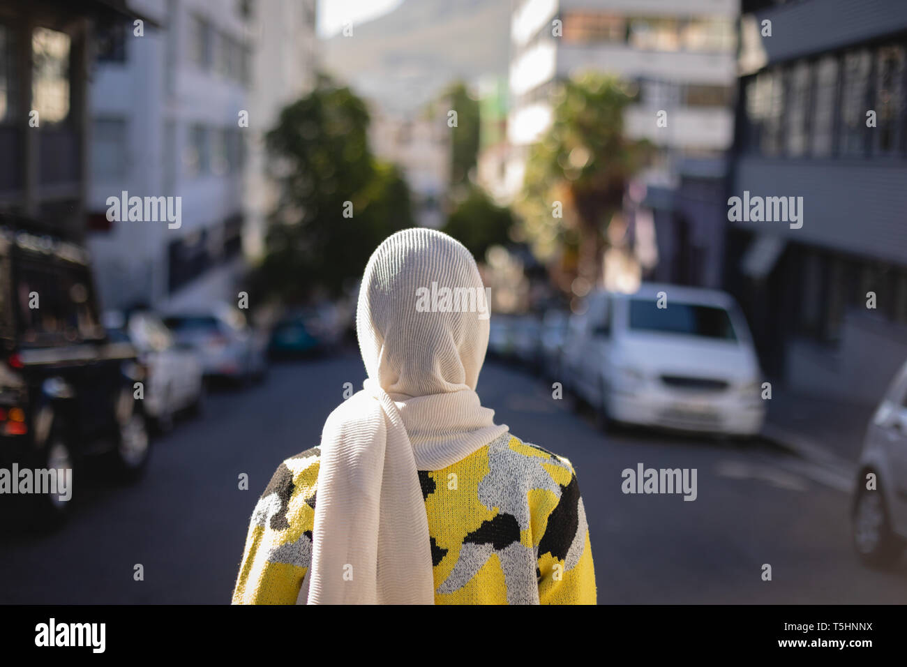 Giovane donna in piedi in strada in una giornata di sole Foto Stock
