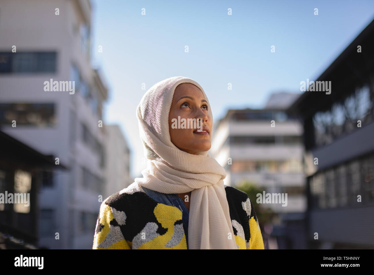 Giovane donna in piedi in strada in una giornata di sole Foto Stock