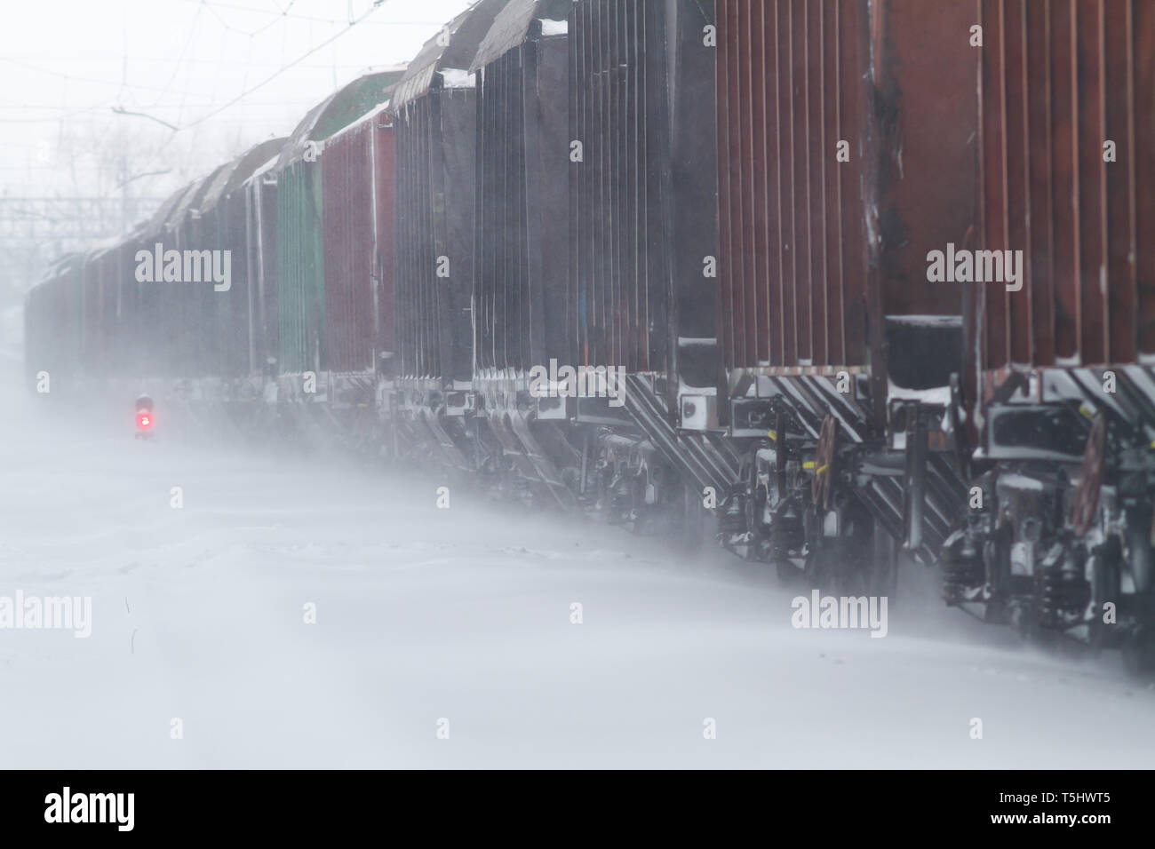 Freight cars andare per ferrovia in una tempesta di neve Foto Stock