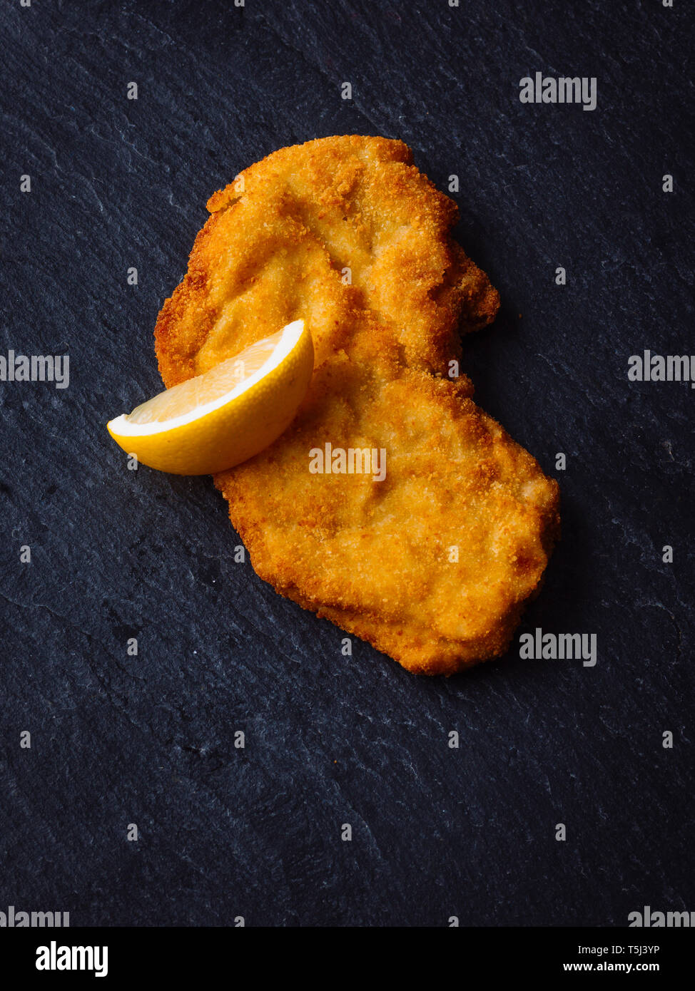 Wiener Schnitzel e la fetta di limone su ardesia Foto Stock