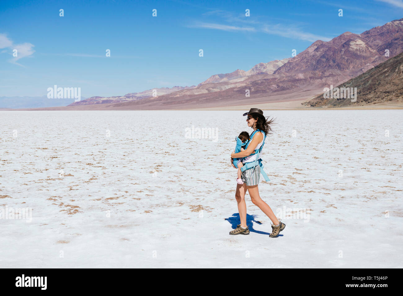 Stati Uniti, California, Parco Nazionale della Valle della Morte, bacino Badwater, madre a piedi con baby girl nel bacino di sale Foto Stock