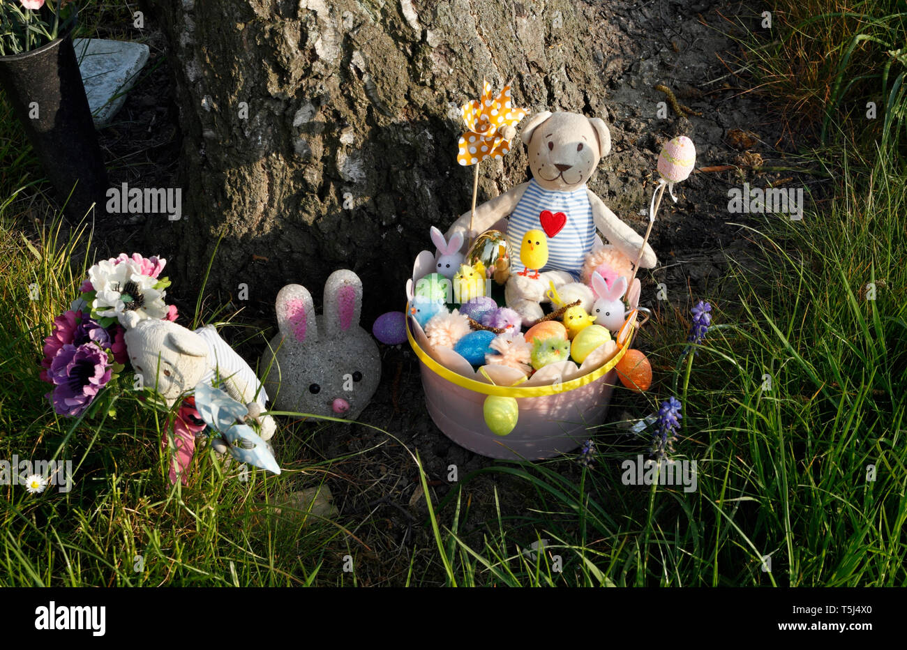 Orsacchiotto pasquale giocattolo e pulcini nel secchiello nel giardino dei giocattoli dolcissimi Foto Stock