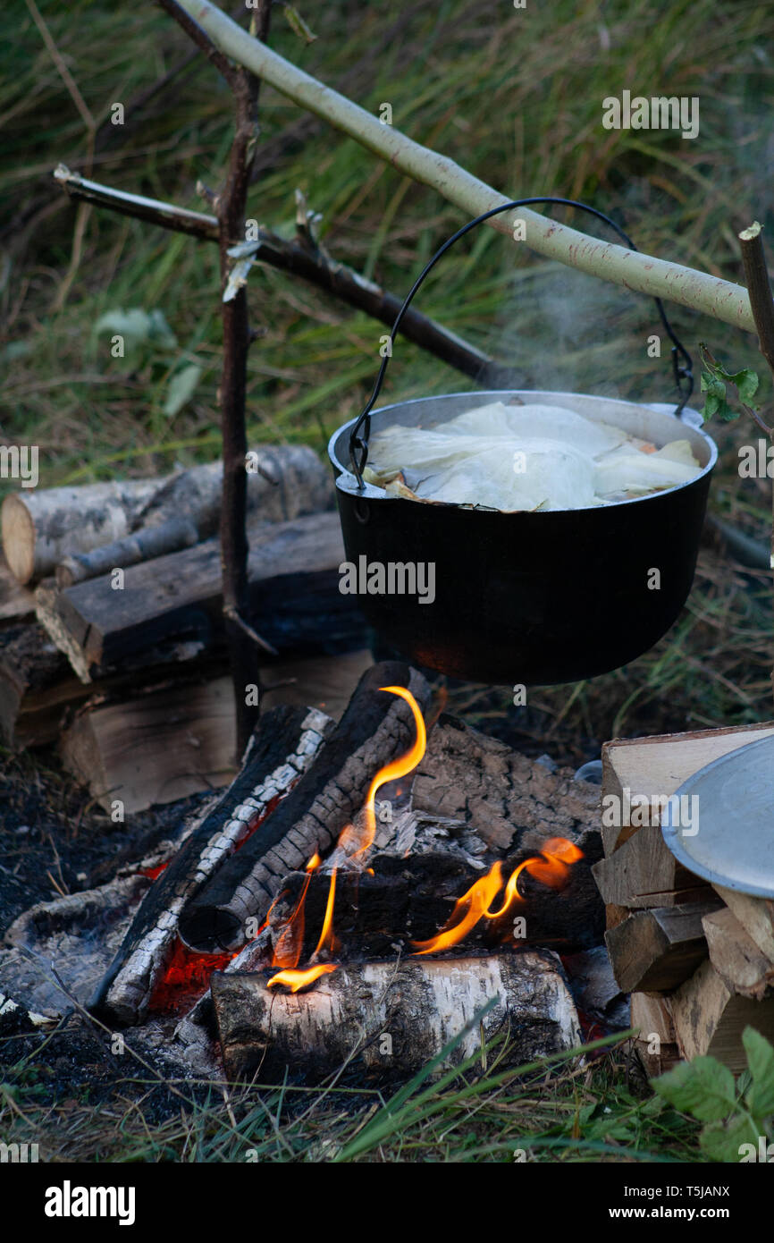 Cucina outdoor in una grande pentola su una fiamma calda. Foto Stock