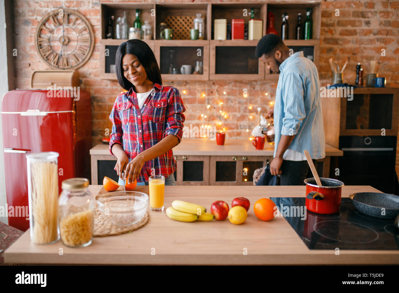 Amore Nero matura la cottura di una cena romantica sulla cucina. Famiglia africana la preparazione di insalata di verdure a casa Foto Stock