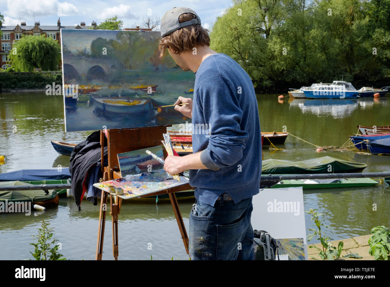 Artista in Richmond riva del fiume Tamigi, Greater London, pittura vista delle barche, acqua e ponte sulla Tela con cavalletto. Maggio 2018 Foto Stock