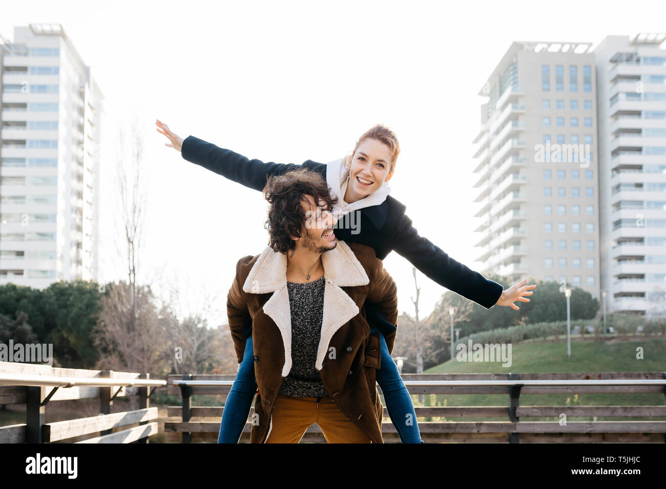 Coppia felice godendo piggyback Ride in città Foto Stock