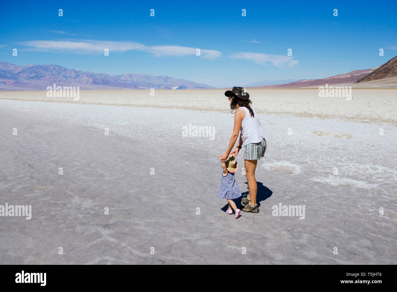Stati Uniti, California, Parco Nazionale della Valle della Morte, bacino Badwater, la madre e il bambino ragazza camminare nel bacino di sale Foto Stock