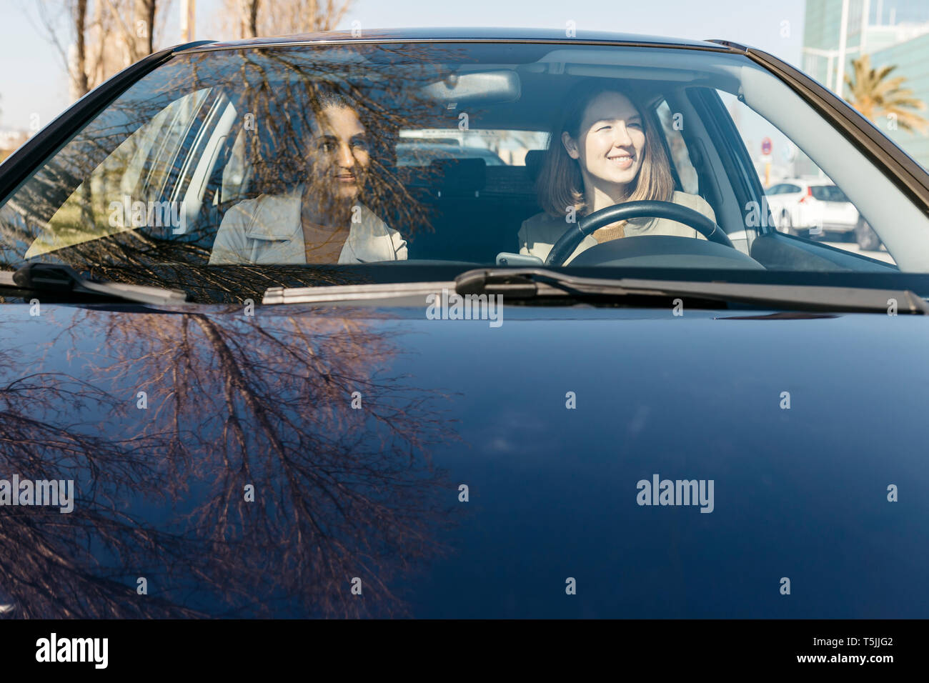 Due donne alla guida di una vettura attraverso la città Foto Stock