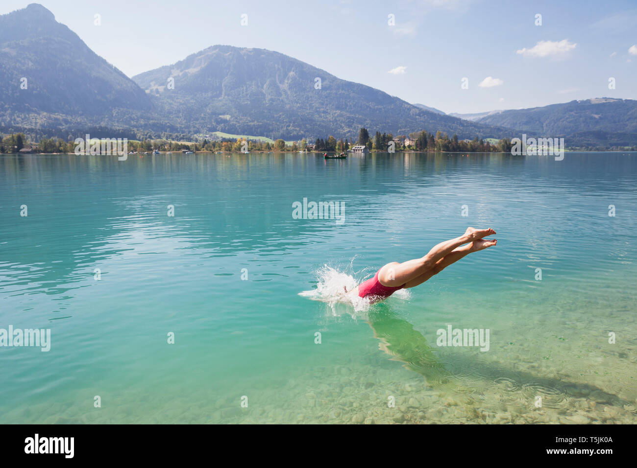 Austria, Alpi, Salisburgo, Salzkammergut, Salzburger Land, Wolfgangsee, donna che si tuffa nel lago Foto Stock