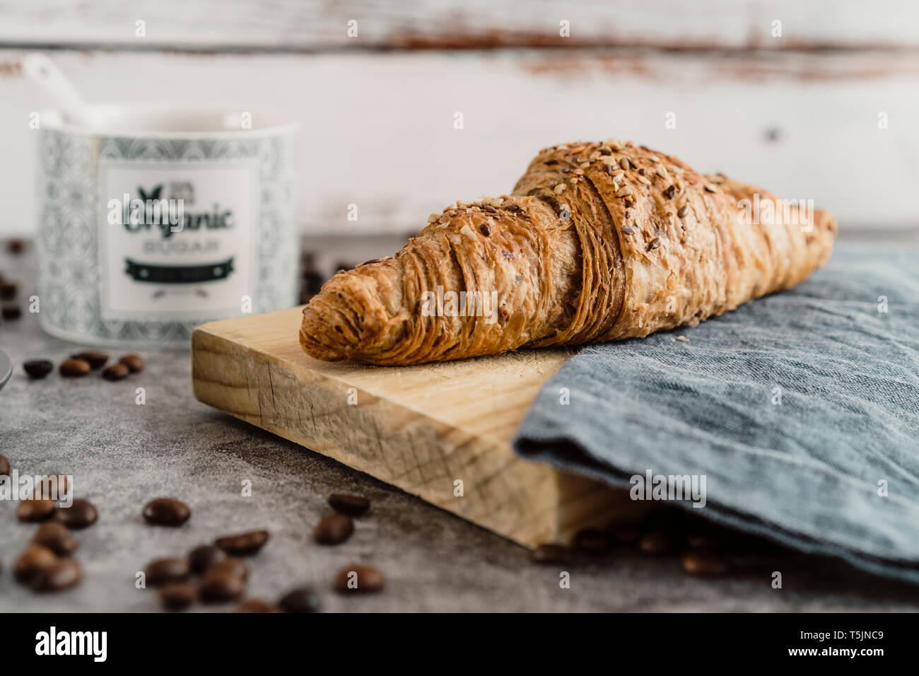 Tutto pasto croissant con grani sul pannello di legno Foto Stock