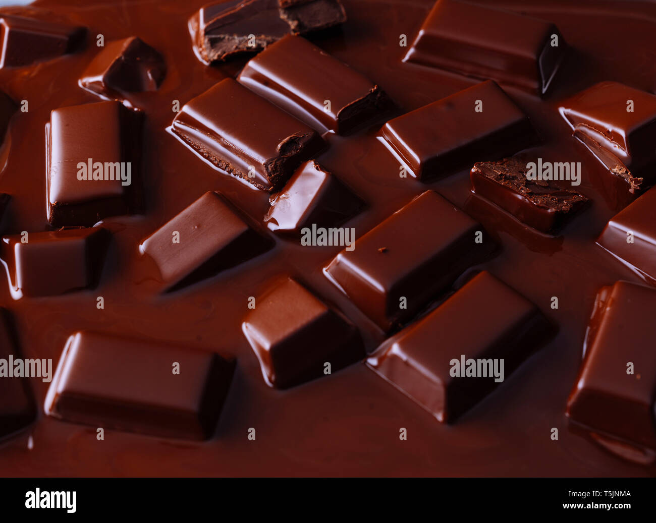 Pezzi di cioccolato fondente fuso in salsa di cioccolato Foto Stock