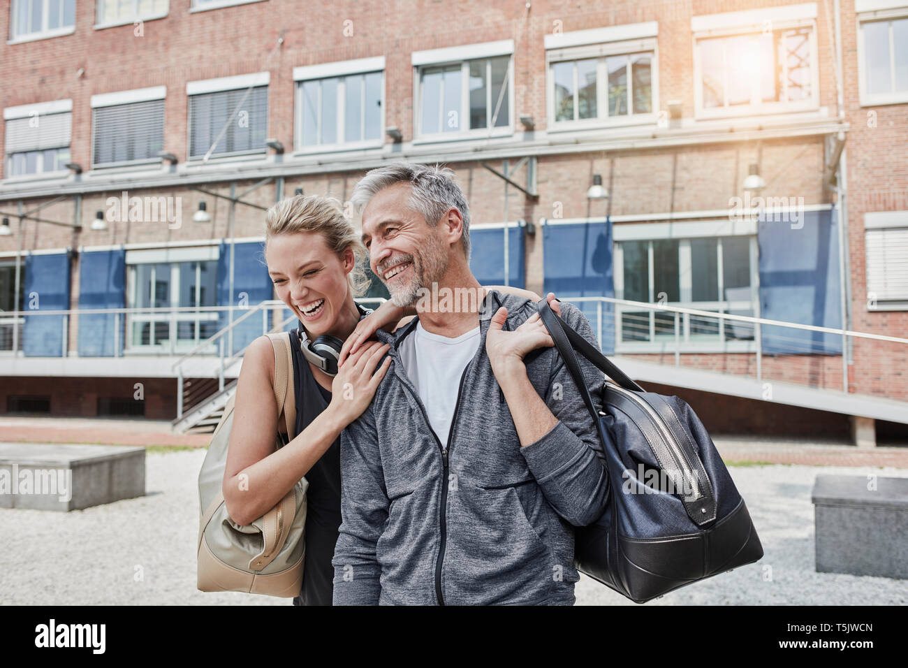 Ritratto di uomo maturo e giovane donna con borsa sportiva di fronte palestra Foto Stock