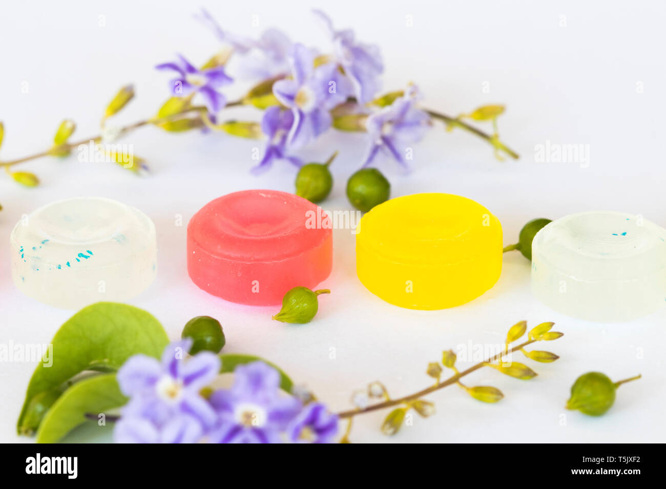 La tosse mal di gola pastiglia colorata estratto di erbe con fiori piatto stile laici su sfondo bianco Foto Stock