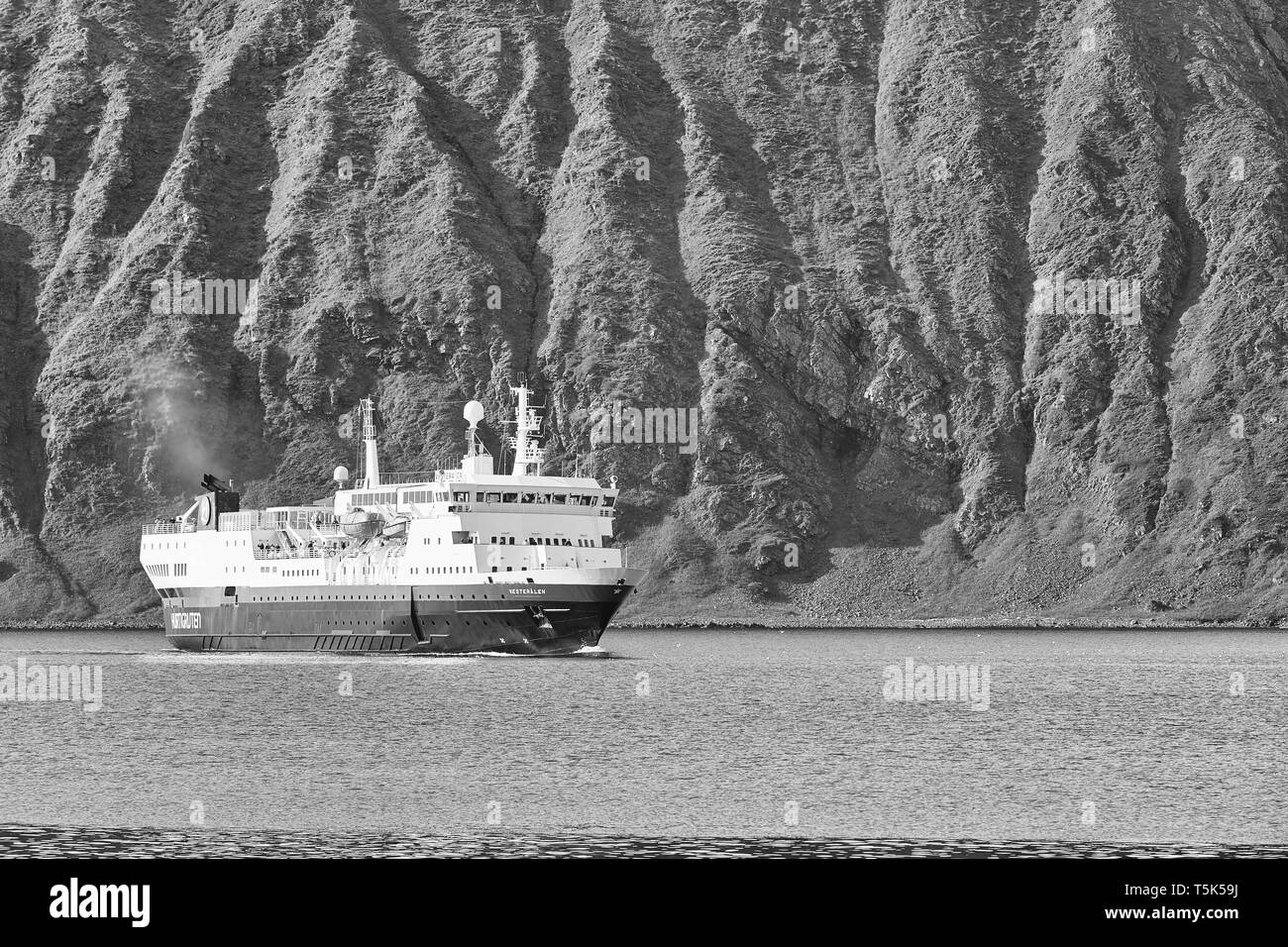 Foto in bianco e nero di Hurtigruten Ferry, MS Vesterålen che si avvicina alla città norvegese di pescatori di Honningsvåg, i lati del fiordo nano la nave Foto Stock