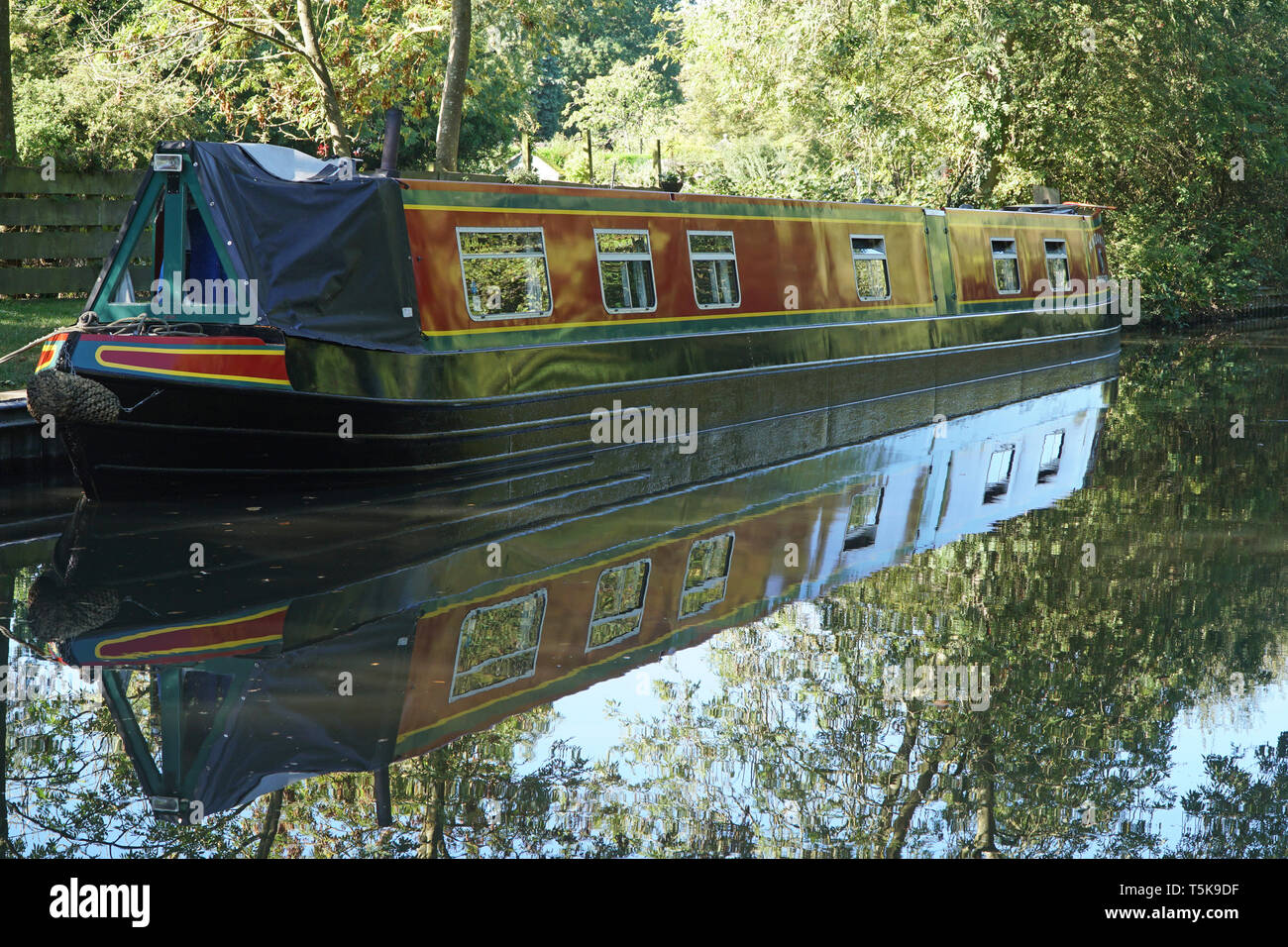 Un canale barge, o longboat, ormeggiata su un tranquillo canale rurale nel Regno Unito in estate Foto Stock