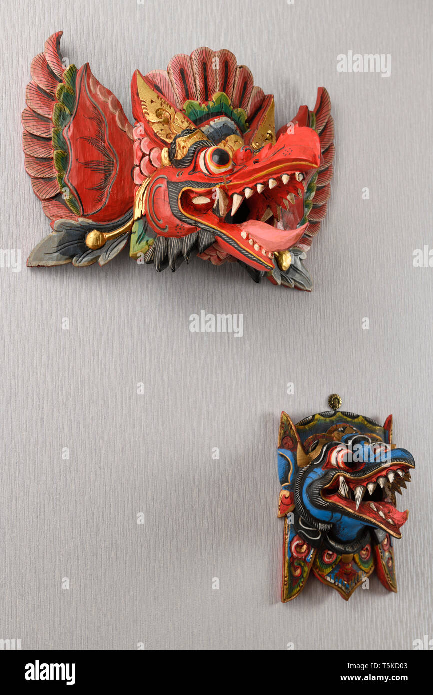 Rosso e blu demone Balinese Danza Barong maschere da Garuda Indonesia appeso a una parete Foto Stock