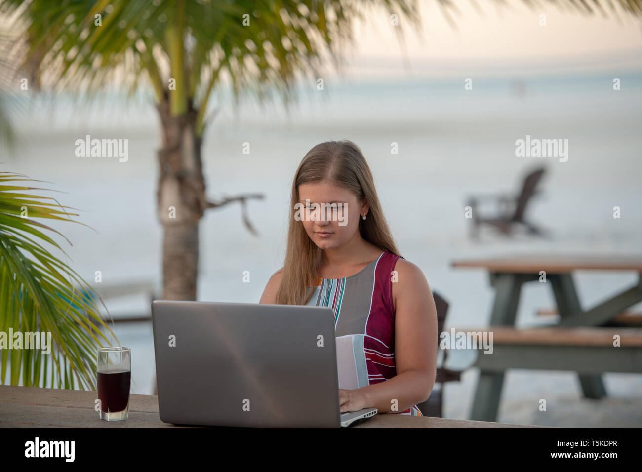 Giovane donna attraente indossando abiti di lavoro portatile sulla spiaggia di mattina in Florida Foto Stock Giovane donna attraente indossando abiti di lavoro portatile sulla spiaggia di mattina in Florida Foto Stock