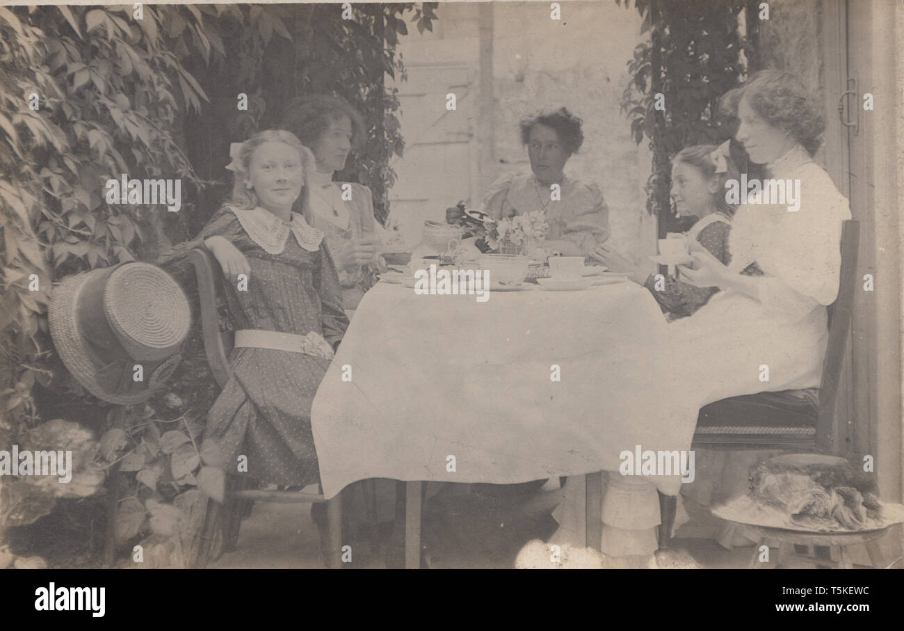 Vintage Cartolina fotografica che mostra un Edwardian famiglia gustando il tè del pomeriggio. Foto Stock