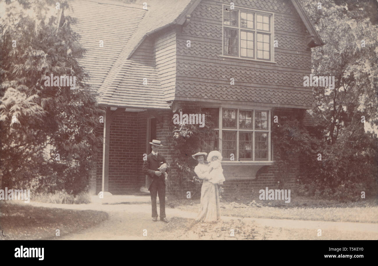 L'annata 1905 Pangbourne, Berkshire Cartolina fotografica che mostra una storica British Casa indipendente. Edwardian giovane e il loro bambino si fermò nel giardino anteriore. Foto Stock