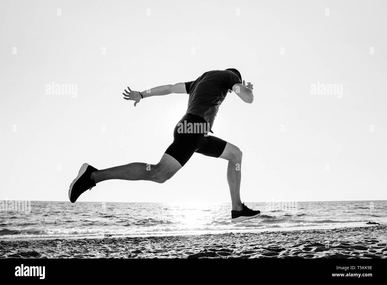 Finish runner atleta sulla spiaggia foto in bianco e nero Foto Stock