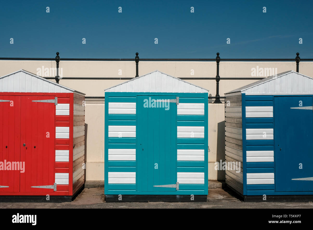 Rosso brillante, turchese e dipinte di blu cabine sulla spiaggia, su una soleggiata giornata d'estate, North Berwick, East Lothian, Scozia Foto Stock