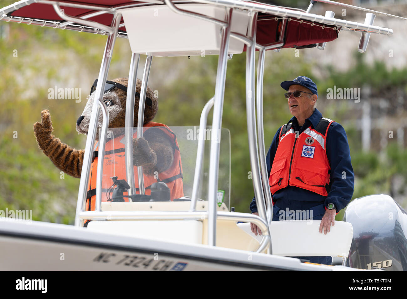 Wilmington, Carolina del Nord, Stati Uniti d'America - Aprile 6, 2019: Il North Carolina Azalea Festival, membri dell'U.S. Coast Guard, ausiliario, su una barca che va verso il basso Foto Stock