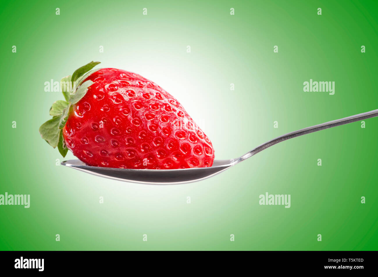 Fragola in un cucchiaio d'argento Foto Stock