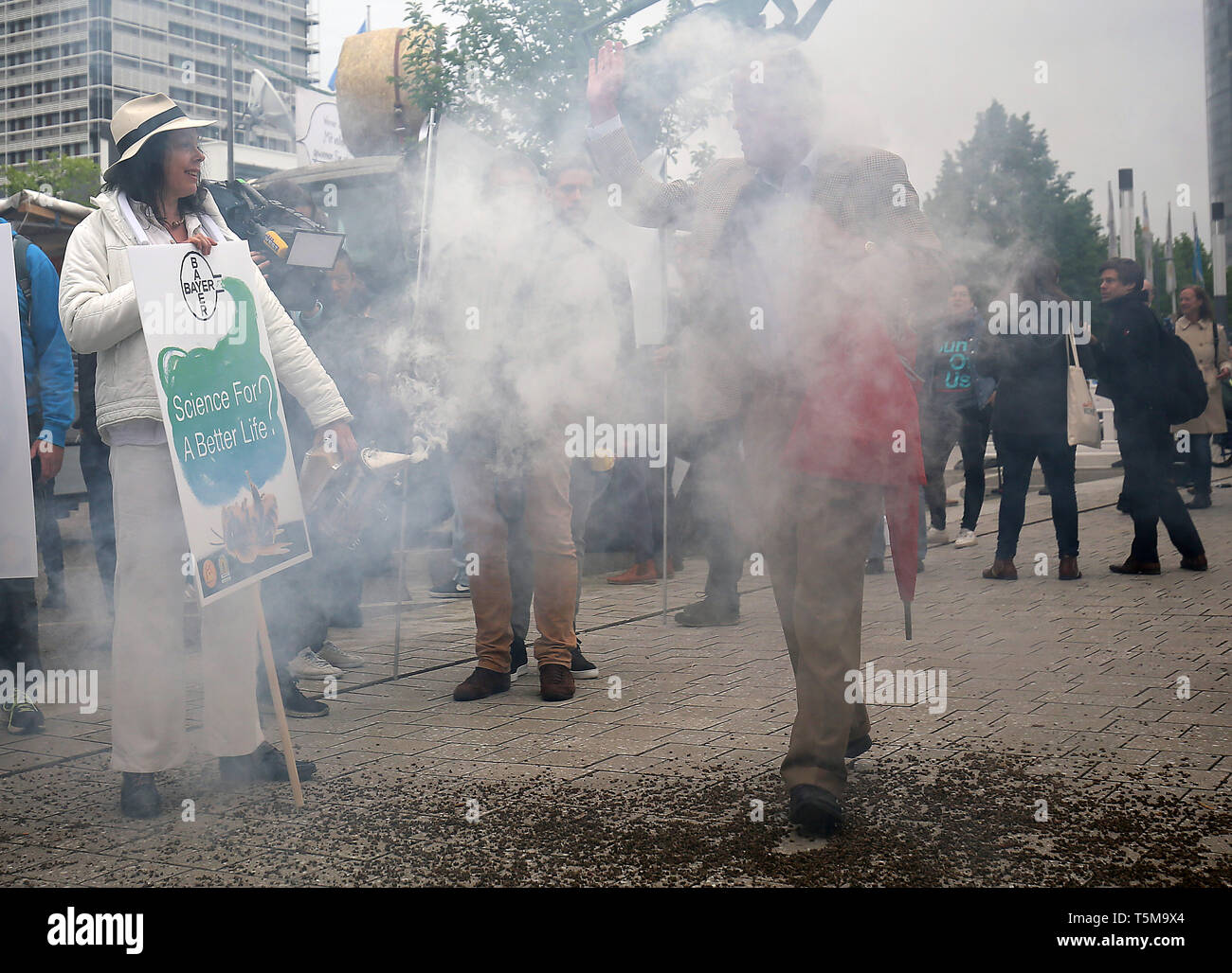 Bonn, Germania. 26 apr, 2019. Gli apicoltori utilizzano un fumatore a generare fumo, mentre i partecipanti arrivano a Bayer annuali di assemblea degli azionisti. Numerose associazioni e iniziative hanno protestato contro la politica della società dell'agrochimica e aziende farmaceutiche. Credito: Oliver Berg/dpa/Alamy Live News Foto Stock