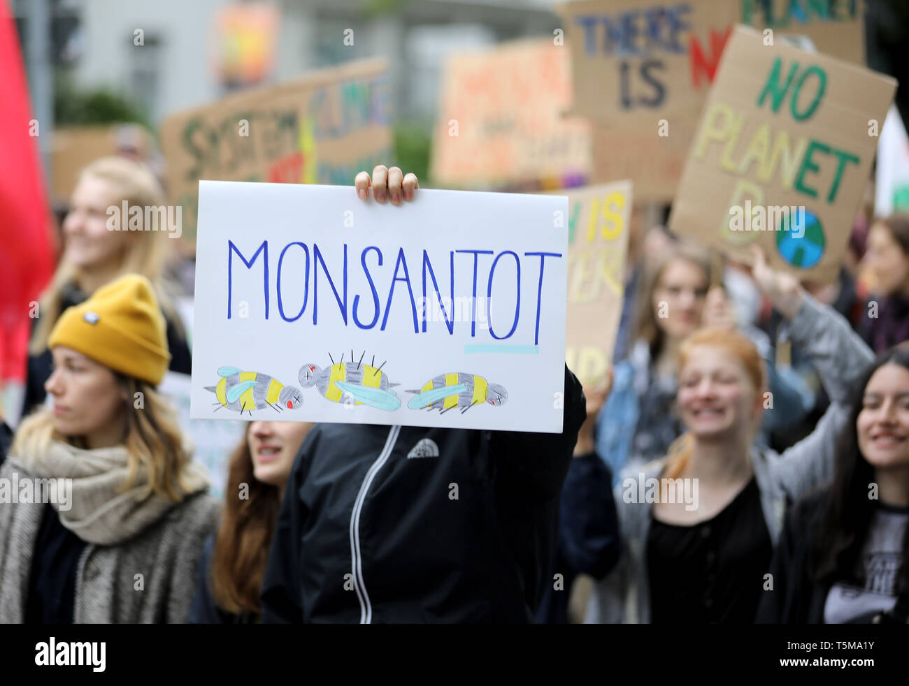 Bonn, Germania. 26 apr, 2019. Gli attivisti del clima del "Venerdì per il futuro " movimento tenere un cartello con la dicitura "onsantot' sul loro modo di Bayer annuali di assemblea degli azionisti. Numerose associazioni e iniziative hanno protestato contro la politica della società dell'agrochimica e aziende farmaceutiche. Credito: Oliver Berg/dpa/Alamy Live News Foto Stock