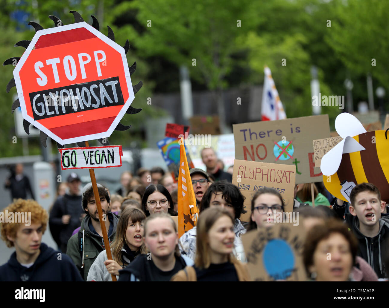 Bonn, Germania. 26 apr, 2019. Gli attivisti del clima del "Venerdì per il futuro movimento" andare a Bayer annuale dell Assemblea degli Azionisti con un segno di 'Stop glifosato'. Numerose associazioni e iniziative hanno protestato contro la politica della società dell'agrochimica e aziende farmaceutiche. Credito: Oliver Berg/dpa/Alamy Live News Foto Stock