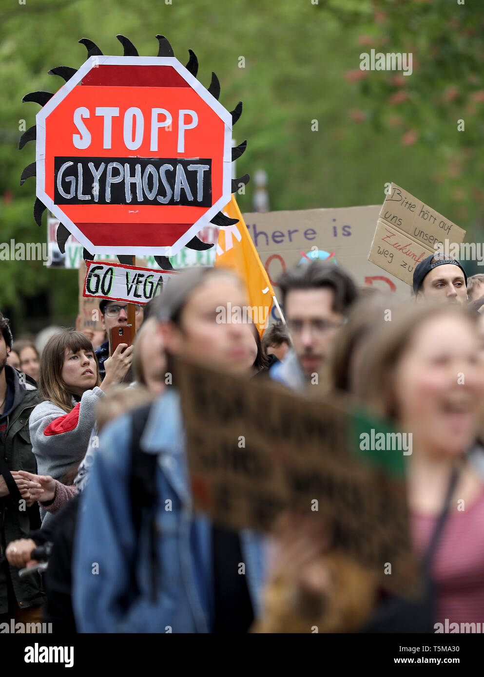 Bonn, Germania. 26 apr, 2019. Gli attivisti del clima del "Venerdì per il futuro movimento" andare a Bayer annuale dell Assemblea degli Azionisti con un segno di 'Stop glifosato'. Numerose associazioni e iniziative hanno protestato contro la politica della società dell'agrochimica e aziende farmaceutiche. Credito: Oliver Berg/dpa/Alamy Live News Foto Stock