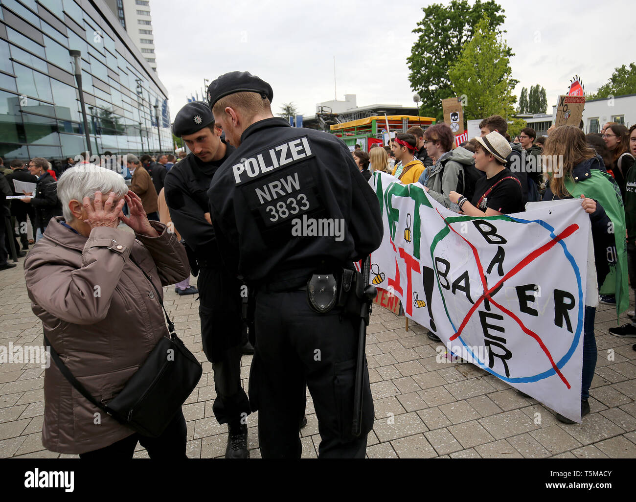 Bonn, Germania. 26 apr, 2019. Poliziotti di parlare con una donna mentre gli attivisti del clima dal venerdì per il movimento futuro dimostrare di fronte Bayer annuali di assemblea degli azionisti. Numerose associazioni e iniziative hanno protestato contro la politica della società dell'agrochimica e aziende farmaceutiche. Credito: Oliver Berg/dpa/Alamy Live News Foto Stock