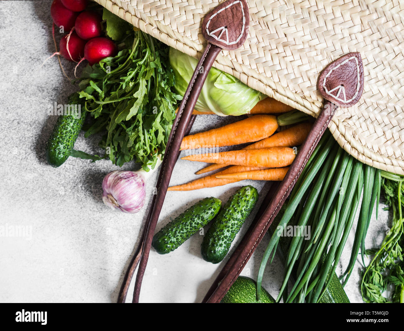 Paglia di vimini sacchetto pieno di naturali freschi ortaggi di primavera. Un sano vegetariano vegano cibo dal mercato locale dalle aziende agricole Foto Stock