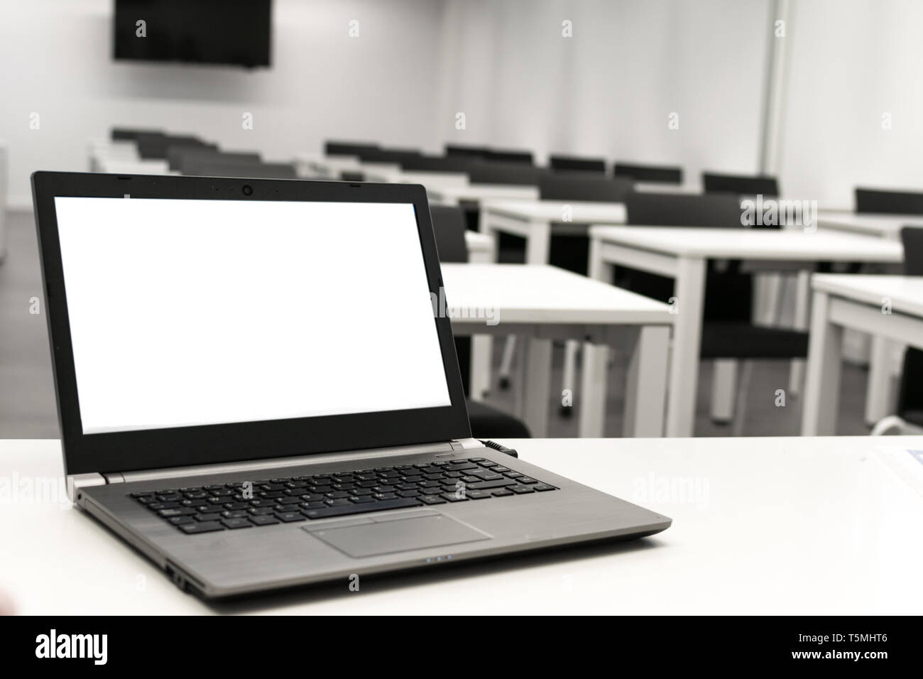 Laptop, business online, insegnante lavoro in classe.portatile messo su un tavolo o una scrivania si trova nella stanza vuota. Foto Stock