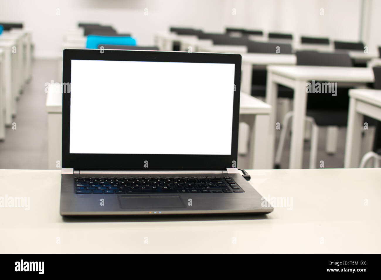 Laptop, business online, insegnante lavoro in classe.portatile messo su un tavolo o una scrivania si trova nella stanza vuota. Foto Stock