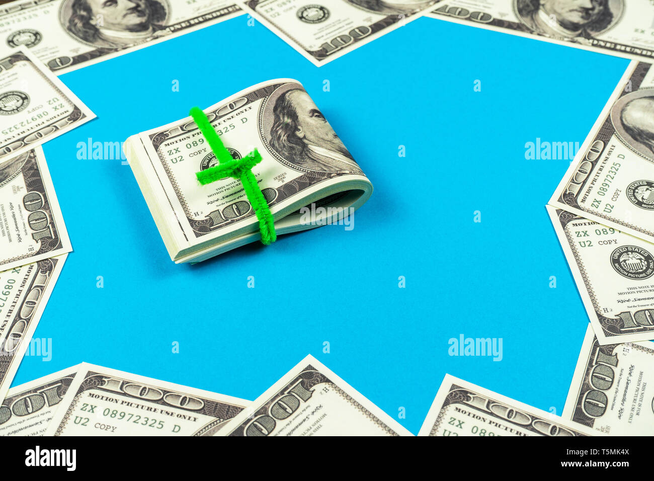 Le fatture del dollaro piegato a metà su fondo azzurro Foto Stock