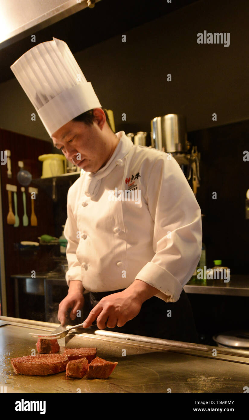 Un Giapponese Teppanyaki grill chef Kobe bistecche di manzo in un ristorante tradizionale a Kobe, in Giappone. Foto Stock