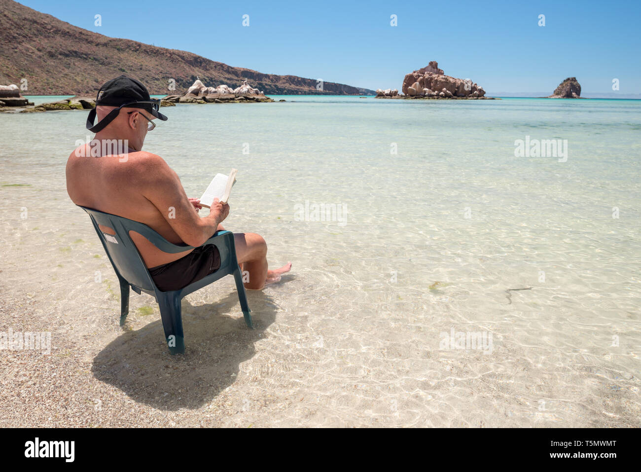 La lettura di un libro su un kayak di mare viaggio, Espiritu Santo Isola, Baja California Sur, Messico. Foto Stock