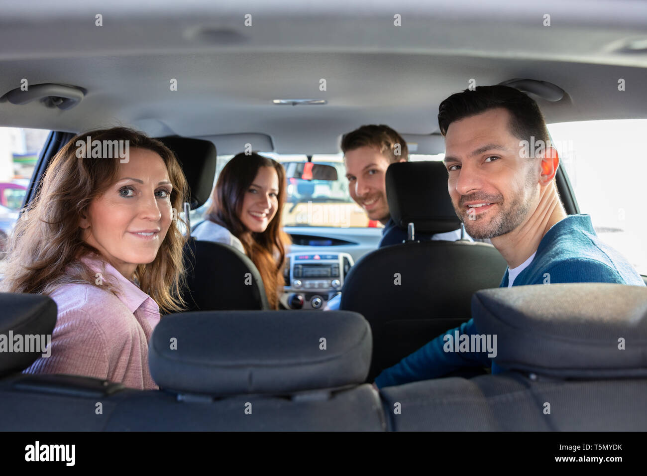 Popolo sorridente seduto all'interno dell'autostop auto Foto Stock