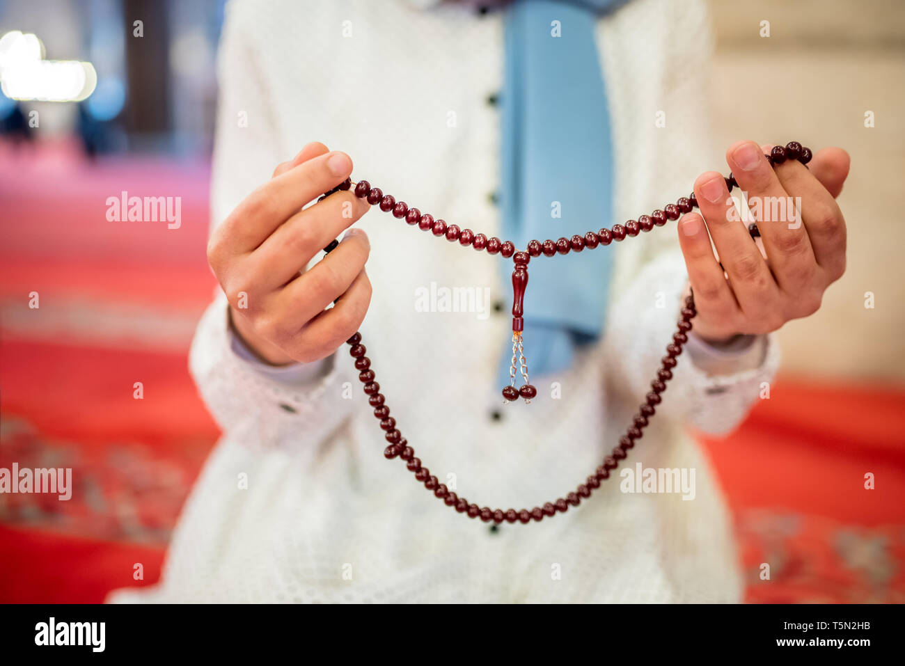 Vista ravvicinata di una donna musulmana mani in hijab tenendo Rosario con le sue mani e la preghiera.La religione pregando concetto. Foto Stock