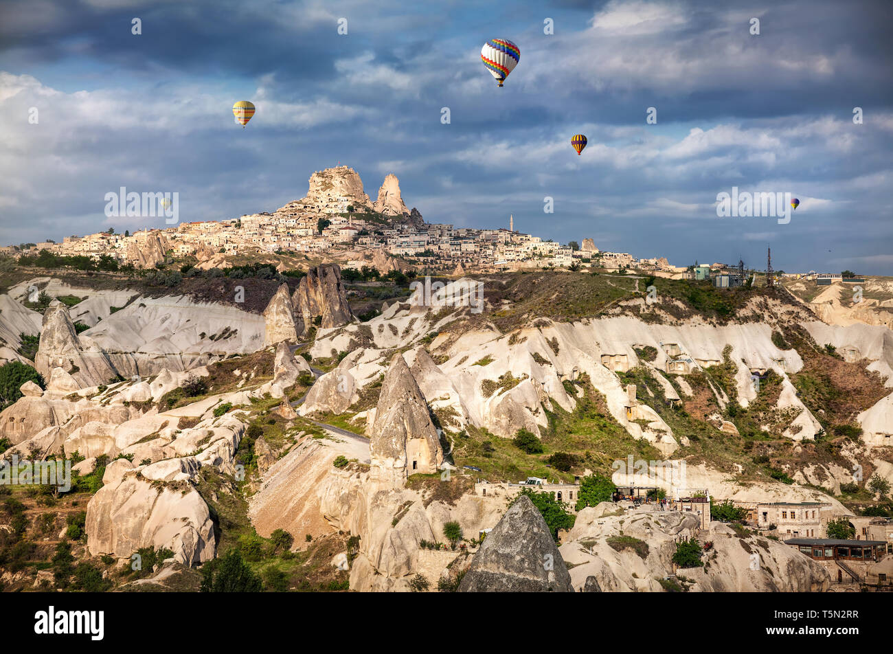 I palloni ad aria calda volando sopra la Cappadocia vicino Castello di Uchisar presso sunrise, Turchia Foto Stock