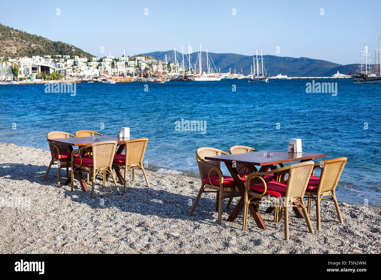 Carino tavolo e sedie e ombrellone in spiaggia al ristorante sul mare a bodrum, Turchia Foto Stock