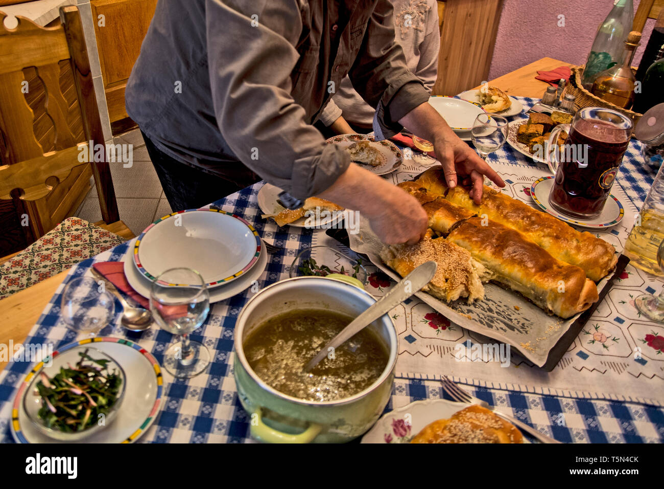 Torte fatte in casa posta su un tavolo con le altre specialità. Gli ospiti sono in attesa di prendere dei luoghi. Foto Stock