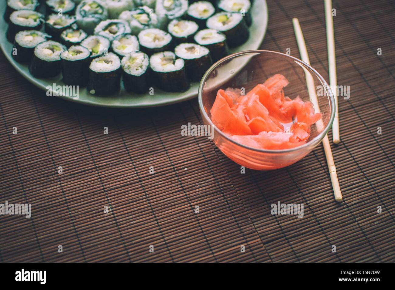 In casa sushi con zenzero e sushi bastoni sul tappeto in legno Foto Stock