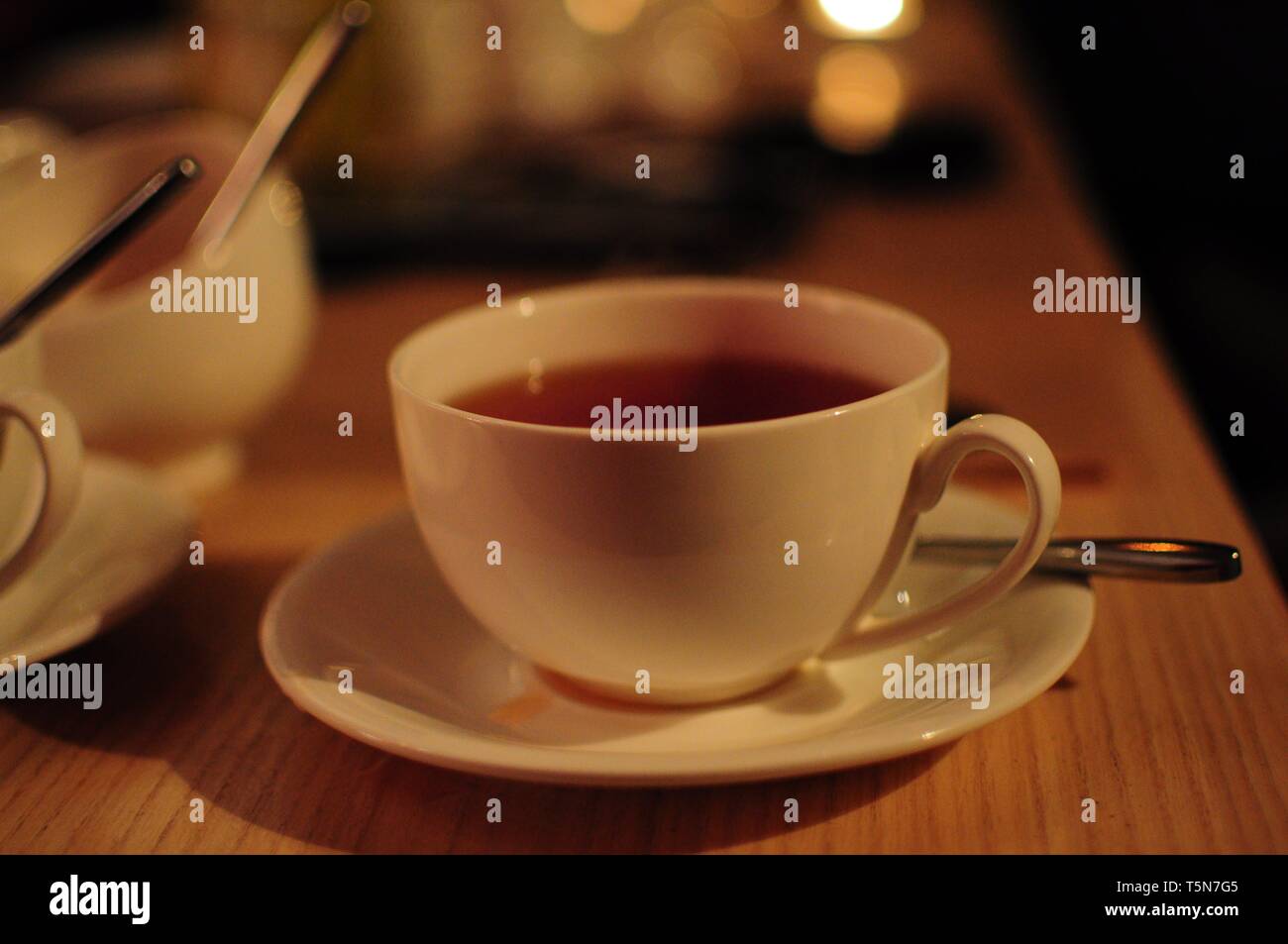 White tazza di tè in cafe. Messa a fuoco morbida dello sfondo Foto Stock