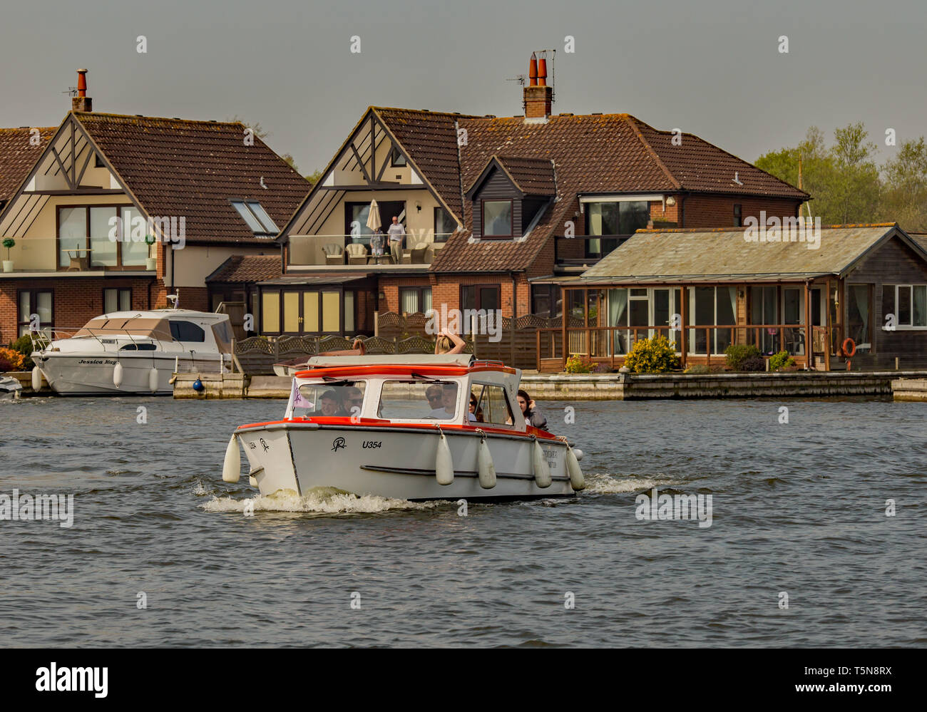 Un gruppo di giovani adulti, composta di tre femmine e quattro maschi, godendo di un viaggio lungo il fiume Bure sul Norfolk Broads in un giorno in barca. Questa è la Foto Stock