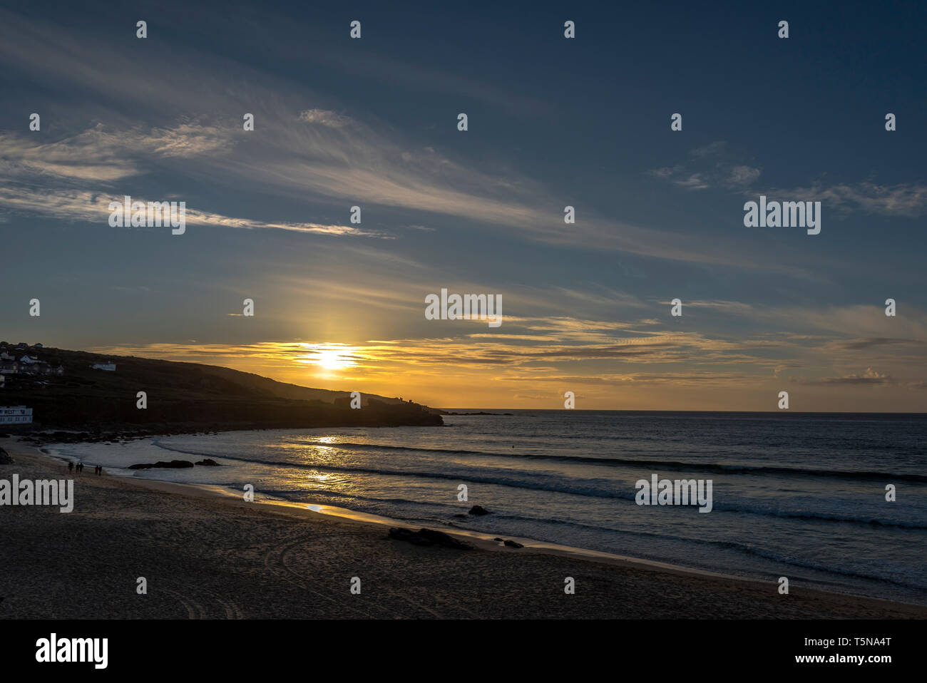 Bellissimo tramonto dorato su impostazione dell'uomo Porthmeor testa surf beach St. Ives Cornwall Regno Unito Europa Foto Stock