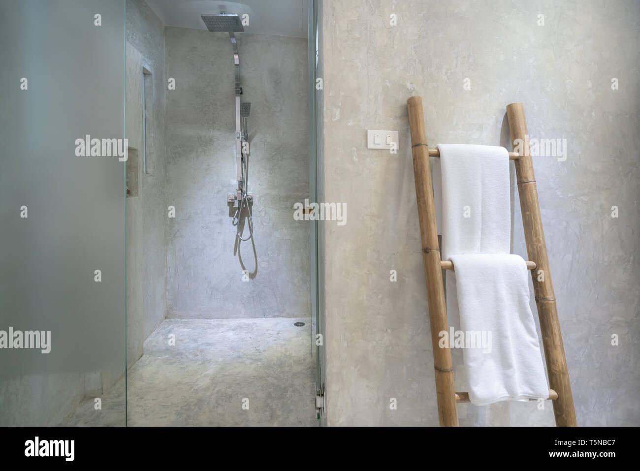 Interno di bagno moderno con doccia e asciugamano bianco a rampa in bagno. Foto Stock